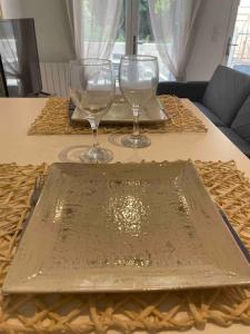 zwei Weingläser auf einem Tablett auf einem Tisch in der Unterkunft LE TEMPS D UNE PAUSE avec jardin accès au canal du midi in Castelnaudary