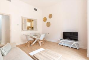 uma sala de estar com uma mesa e uma televisão em Merced10 2C em Málaga