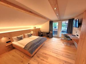 een slaapkamer met een bed en een bureau met een computer bij Haus Denneberg in Oberstaufen