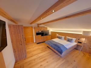 ein Schlafzimmer mit einem großen Bett und Holzböden in der Unterkunft Haus Denneberg in Oberstaufen