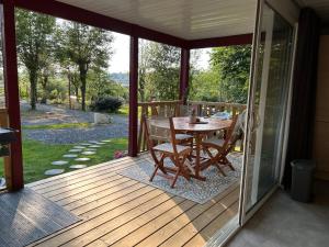 una veranda riparata con tavolo e sedie sopra di Erreka pays basque a Hasparren