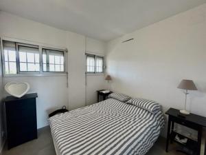 - une chambre avec un lit rayé et 2 fenêtres dans l'établissement Appartement Argelès-sur-Mer, 2 pièces, 6 personnes - FR-1-388-178, à Argelès-sur-Mer