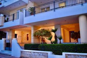 a large white building with stairs and plants at Nik apartment in Ierapetra
