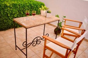 a table with two glasses of wine and a chair at Nik apartment in Ierapetra