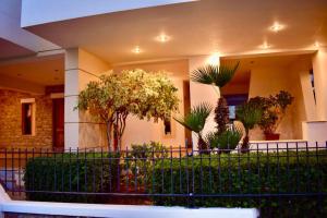 a building with a fence with trees and plants at Nik apartment in Ierapetra +3 photos