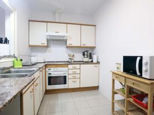 una cocina con armarios blancos y fregadero en D16241 Sant Telm II, en Sant Feliu de Guíxols