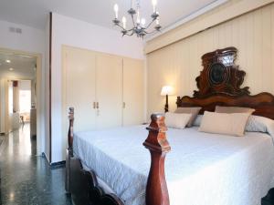1 dormitorio con 1 cama grande y cabecero de madera en D16241 Sant Telm II, en Sant Feliu de Guíxols