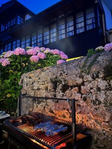 a grill with pink flowers on a wall at Los Cuetos in Santianes