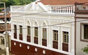 biały budynek z oknami i balkonem w obiekcie Serra Golfe Apart Hotel w mieście Bananeiras