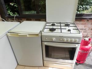 a kitchen with a stove and a refrigerator at Une pause... Quelque part in Le Torp-Mesnil