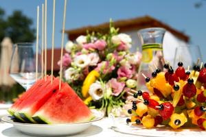 a table with two plates of fruit and a bowl of watermelon at Imanje Lotus Garden in Šabac