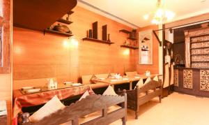 un restaurante con paredes de madera, mesas y sillas en Treebo Trend Regency - Bund Garden, Dhole Patil Road, en Pune