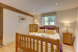 a bedroom with a wooden bed and a window at Owl Barn in Morston