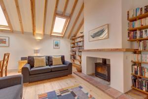 a living room with a couch and a fireplace at Owl Barn in Morston