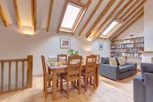 a dining room and living room with a table and chairs at Owl Barn in Morston