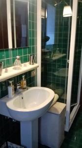 un bagno piastrellato verde con lavandino e doccia di Visit Palladio B&B a Vicenza