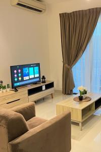 ein Wohnzimmer mit einem TV, einem Sofa und einem Tisch in der Unterkunft Teega Suites Puteri Harbour_5min Legoland #6Pax (16) in Nusajaya
