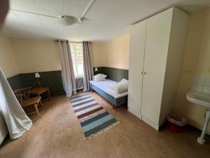 um quarto com uma cama, uma secretária e uma mesa em Skagagården, Sjömarken em Undenäs