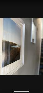 a mirror on a wall with a picture of a beach at Sea View Terrace in Donaghadee