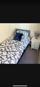 a bedroom with a bed with a blue and white comforter at Sea View Terrace in Donaghadee