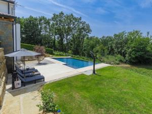 a backyard with a swimming pool and a lawn at Rokvilla in Motovun