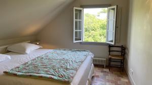 una camera con letto, finestra e sedia di Guest House Le Clos Pasquier a Blois