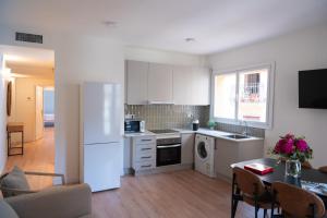 a kitchen with a white refrigerator and a table at Rambla de Mar Apartments in Barcelona