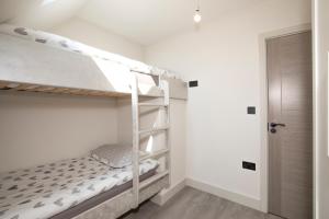 ein Schlafzimmer mit Etagenbetten in einem weißen Zimmer in der Unterkunft Luxury spacious modern new apartment -fully equipped in London