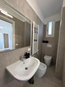 uma casa de banho com um lavatório, um WC e um espelho. em Casa Vacanze Merletto em Imperia