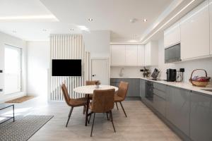 a kitchen with a table and chairs in a room at Luxury spacious modern new apartment -fully equipped in London