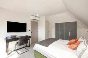 Schlafzimmer mit einem Bett und einem Schreibtisch mit einem TV in der Unterkunft Luxury spacious modern new apartment -fully equipped in London