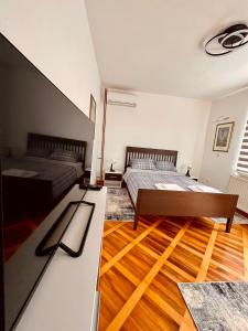um quarto com 2 camas e piso em madeira em Dekster apartmani em Valjevo
