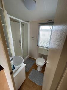 a bathroom with a white toilet and a sink at The Willerby Vacation in Leysdown-on-Sea