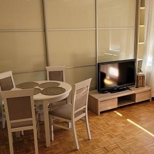 uma sala de jantar com uma mesa e uma televisão em Apartament em Nakło nad Notecia