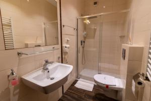ein Bad mit einem Waschbecken, einer Dusche und einem WC in der Unterkunft Atlantic Aparthotel in Krakau