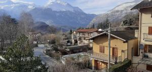 a village with buildings and mountains in the background at Casa Quokka in Meana di Susa