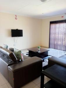 - un salon avec un canapé et une table dans l'établissement Estoby Executive guest house, à Witbank