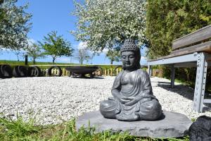 a statue of a buddha sitting on a rock at Naturgeflüster Chalet in Morbach