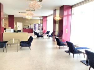 a waiting room with chairs and tables in a lobby at J Hotel Rinku in Tokoname