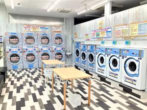 a laundry room with washing machines and a table at J Hotel Rinku in Tokoname