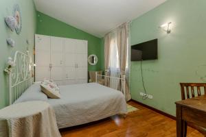 a bedroom with green walls and a bed and a table at Villa Lolù in Terranuova Bracciolini +99 photos