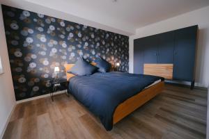 a bedroom with a large bed with a wall at Ferienapartments Seepark Möhnesee in Möhnesee