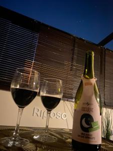 two glasses of red wine next to a bottle of wine at Love Space Sensory Spa & relax suite in Santa Maria delle Mole