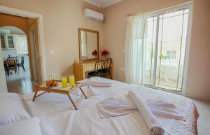 sypialnia z białym łóżkiem ze stołem w obiekcie Joanna’s apartment w mieście Rodos