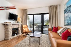 a living room with a couch and a fireplace at Lantern 1 bedroom terrace with mountain views in Thredbo