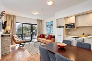 a kitchen and living room with a table and chairs at Lantern 1 bedroom terrace with mountain views in Thredbo