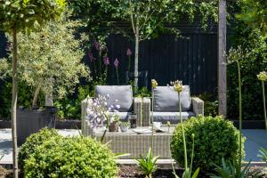 a garden with a couch and chairs and plants at Moonwood House in Beaulieu
