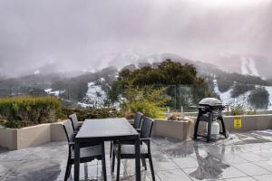 una mesa y sillas con vistas a la montaña en Lantern 1 bedroom terrace with mountain views, en Thredbo