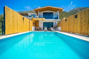 a swimming pool in front of a house at KaşKalkan Honeymoon Villa with Seaview in Kalkan