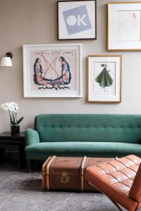 ein Wohnzimmer mit einer grünen Couch und einem Koffer in der Unterkunft Mimosa Hotel in Westerland